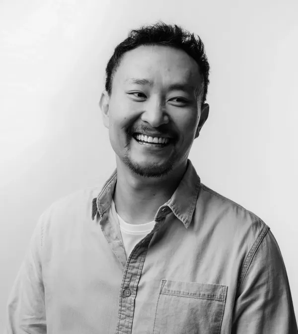 Cesar Matsumoto sorrindo, em foto preto e branco